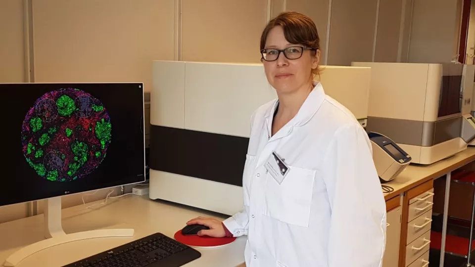 Lina Olsson framför en dator som analyserar celler