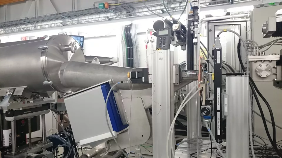 Foto taget vid synkrotronanläggningen PSI i Schweiz. Röret som skickar ut röntgenstrålningen syns till vänster på bilden. Provet sitter på den lilla kopparplattan något till höger, i bildens högra kant syns detektorn. Foto: Jenny Andersson