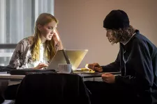 Två studenter pluggar vid ett bord.