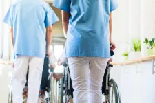 Skötare leder fram personer som sitter i rullstol