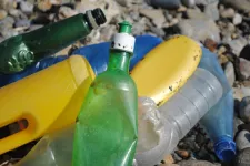 Plastflaskor i olika färger på en strand. Foto: Pixabay.