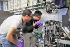 Två forskare studerar en analysapparat i ett laboratorium.