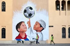 Foton som visar en målning av en fotboll och två pojkar framför byggarbetare.