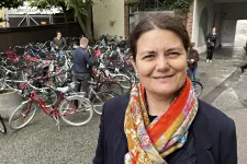 Kvinna med sjal. Parkerade cyklar i bakgrunden. Foto