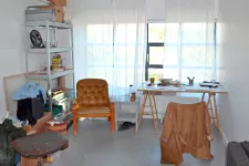 Foto inifrån en ateljé på Konsthögskolan i Malmö, med stolar, skrivbord och konstnärsmaterial.