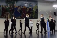 Bågdansen framförs framför muralmålningen Dansen.