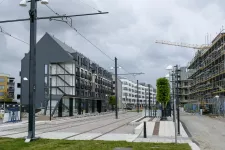 A tram track with new houses in the background. Photo.