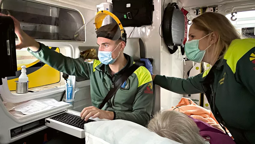 Två sjuksköterskor i trång ambulans kontrollerar något på skärm. Foto: Åsa Hansdotter