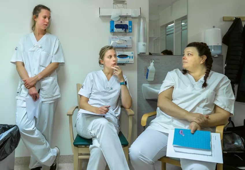 Tre kvinnor i sjukvårdskläder.