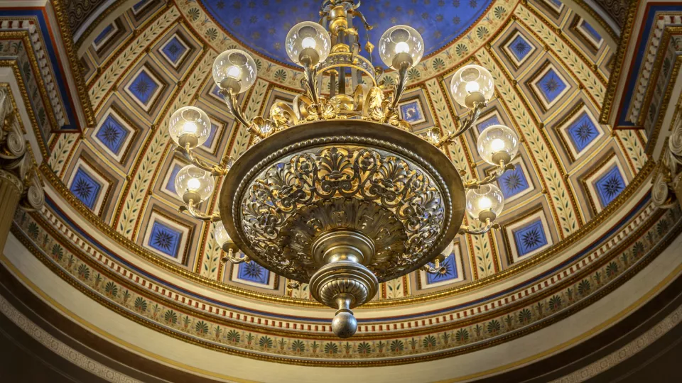 Universitetshusets innertak som går i blått och guld med en stor kristallkrona. Foto Kennet Ruona.