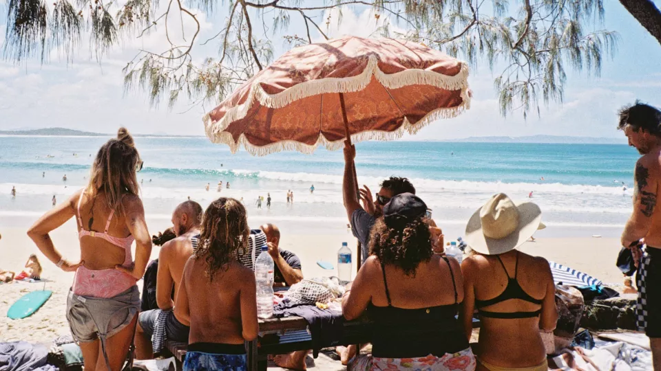 Personer solbadar på en strand.