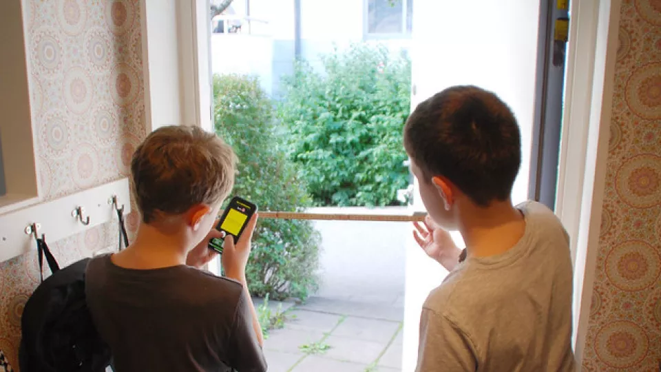 bild på två pojkar som mäter ingången till en lägenhet. foto.