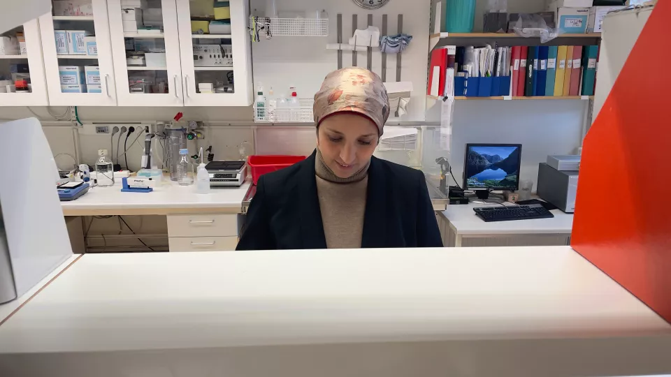 Kvinna ser ned på sin arbetsbänk i labbet. Hon ser koncentrerad ut.