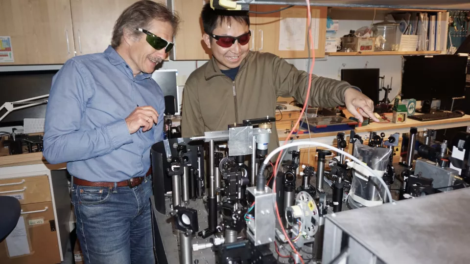 Två manliga kemiforskare i laserspektroskopilaboratorium.
