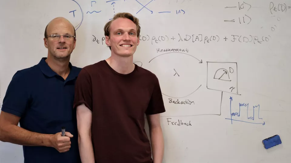 Två manliga forskare framför en whiteboard med uträkningar.