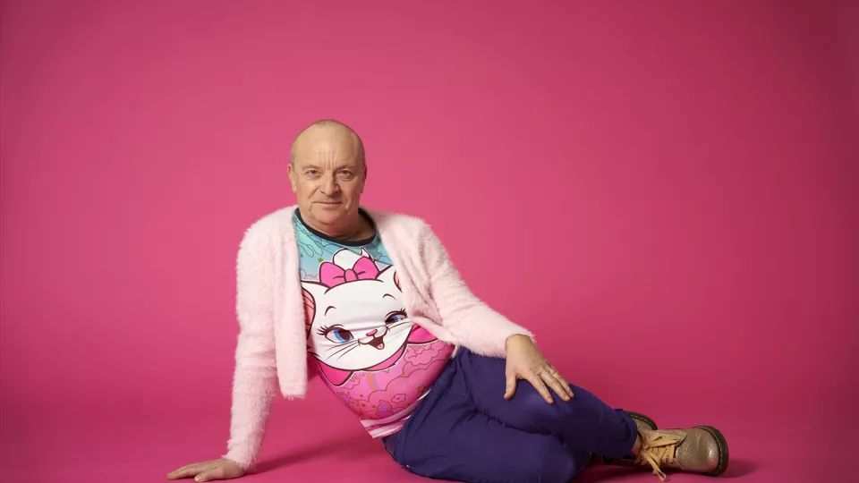 Fotografi på Jonas Gardell mot en rosa bakgrund. 