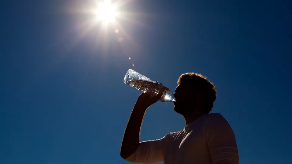 man dricker vatten under sol