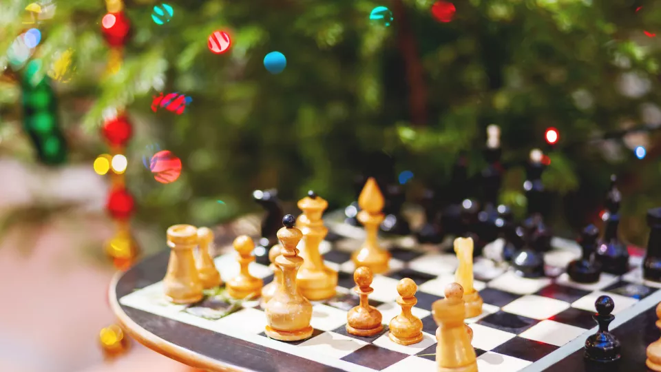 Schackspel framför en julgran. Foto.