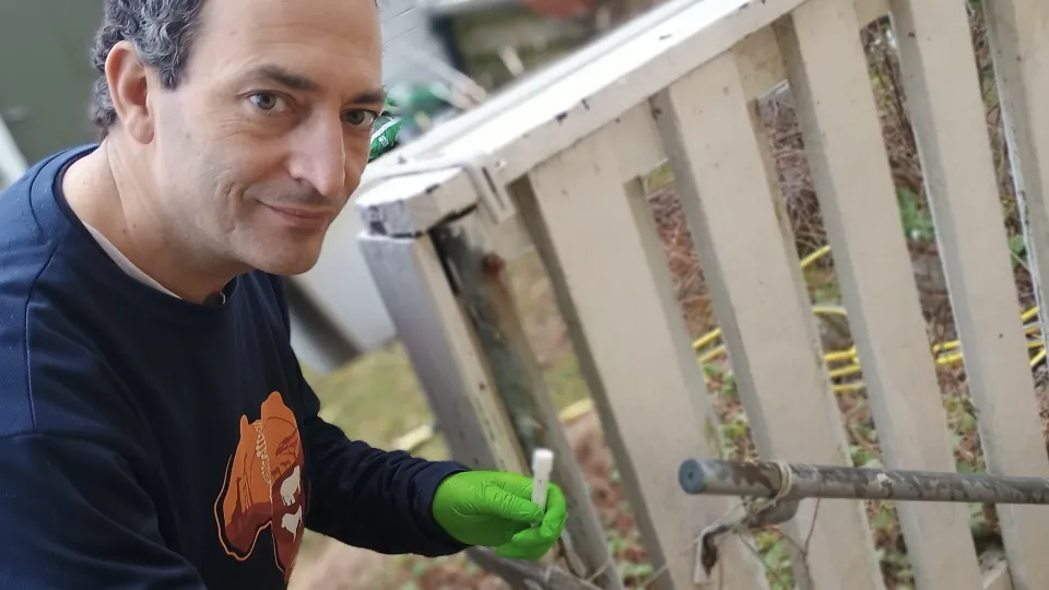 Man som sitter på huk vid en trappa.