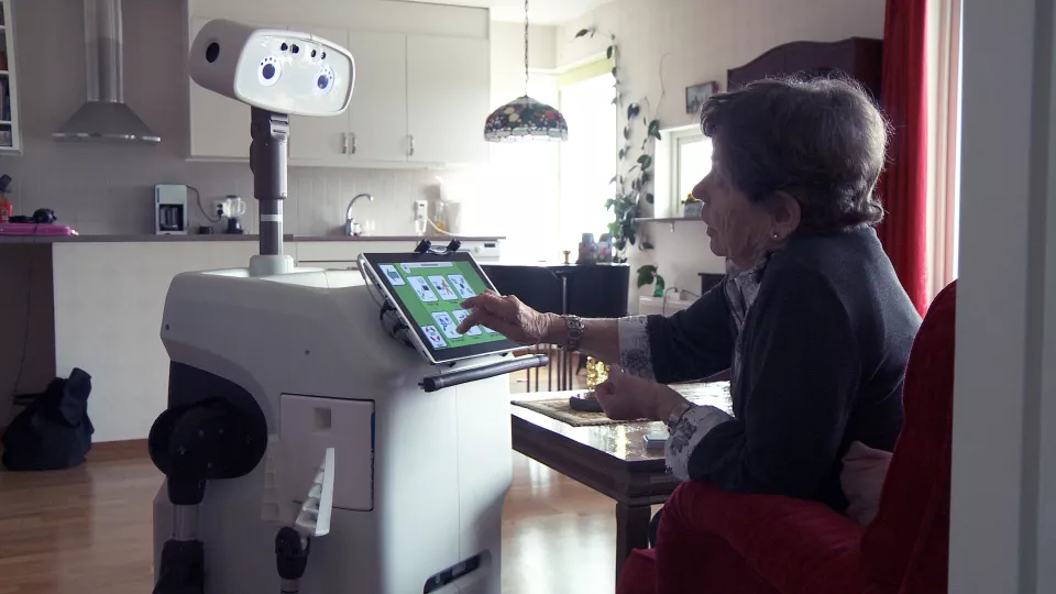 Ella Lundström,  89 år, interagerar med roboten Hobbit.