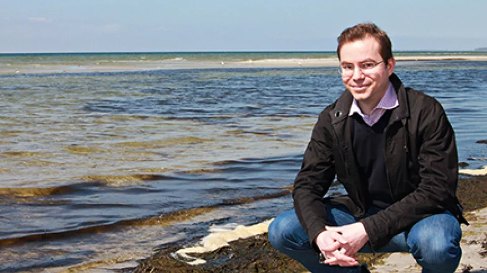 Matematikern Erik Wahlén vid stranden med havet i bakgrunden
