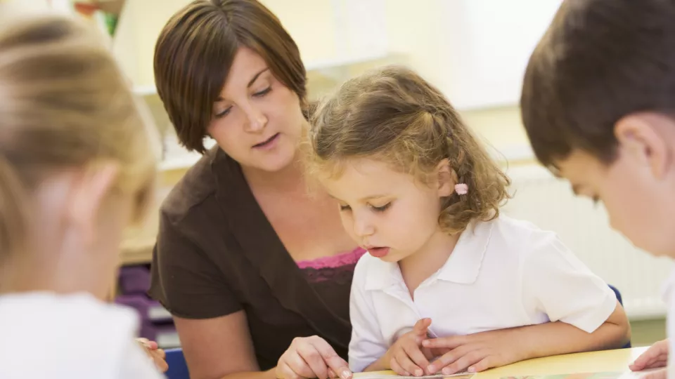 Skolbarn i klassrummet får hjälp av sin lärare