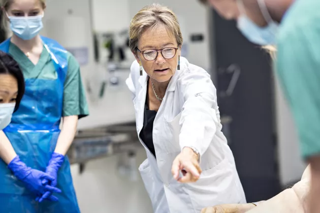 Kvinna undervisar läkarstudenter. 