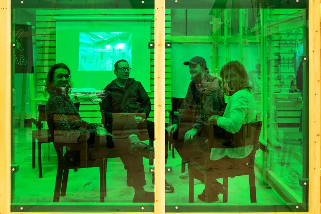 Personer som sitter bakom ett grönt glas