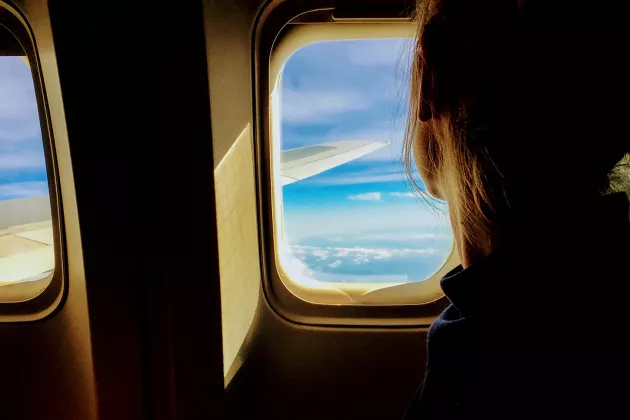 Kvinna tittar ut genom flygplansfönster. 
