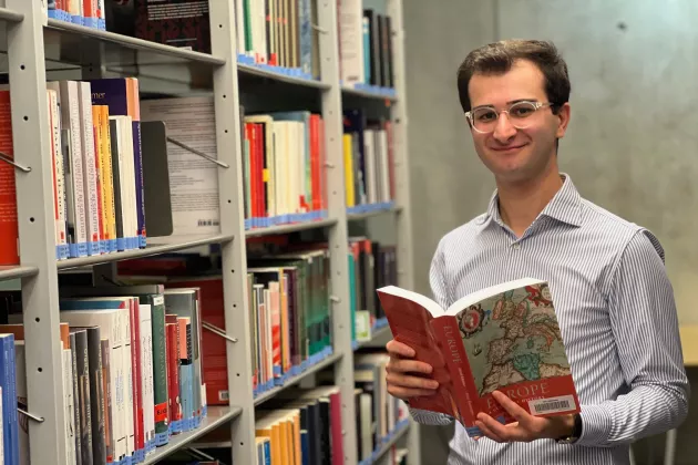 Man in front of bookshelves 