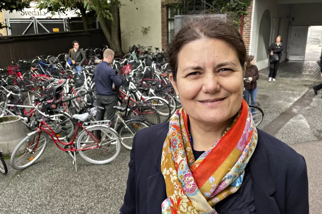 Kvinna med sjal. Parkerade cyklar i bakgrunden. Foto