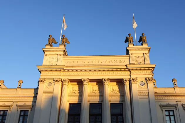 Universitetshuset i morgonsol mot blå himmel. Foto.