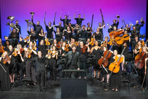 Lübecks universitetsorkester_Foto_Ulrich Witt.jpg Orkestermedlemmar i konsertsal. Foto.