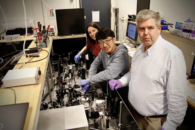 Tre kemiforskare vid en experimentstation.