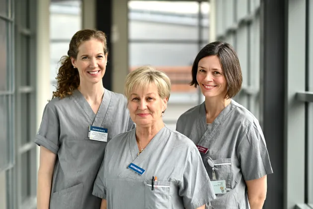 Cecilia Häggsgård, Christine Rubertsson och Eva Åsman är klädda i grå bussarong som bärs i hemvård, när de besöker familjer hemma. Foto: Åsa Hansdotter. 