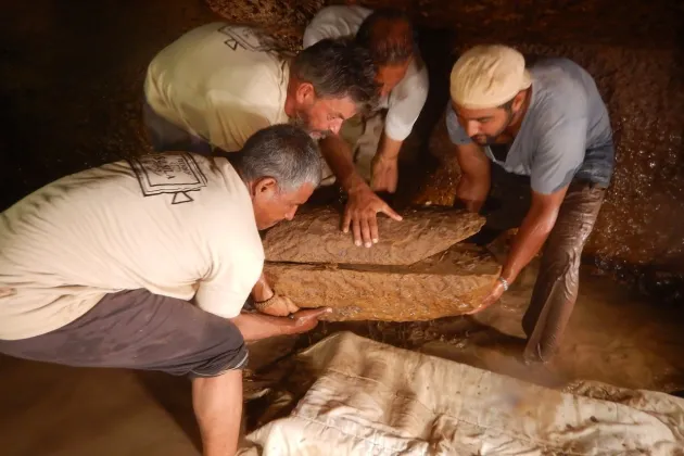 Teamet förbereder sig inför att lyfta en av barnsarkofagerna.