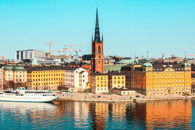 Stockholm, stadssiluett vid vatten och en båt. Foto.