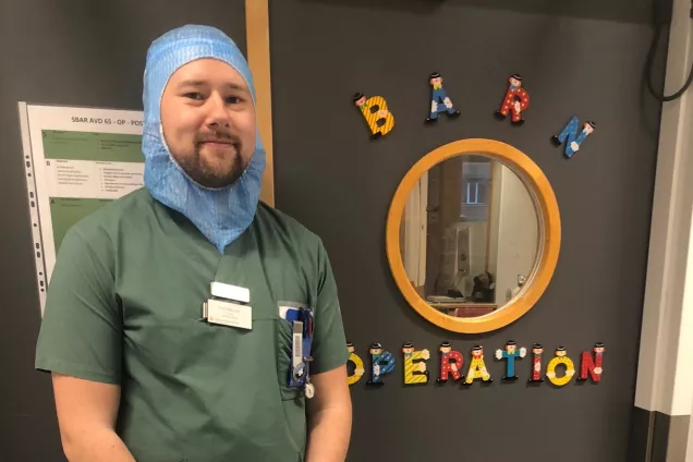 Emil står utanför en barnoperationsavdelning. Foto.