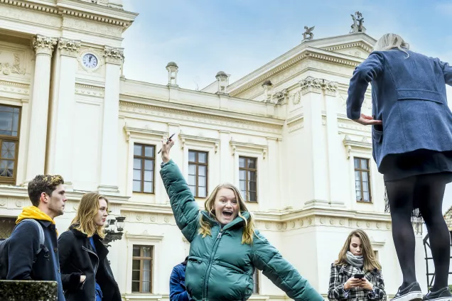 Ett gäng studenter som står utanför Universitetshuset. En av dem är väldigt glad och skrattar och hoppar. Foto Kennet Ruona.