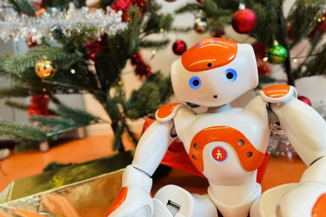 IMG_3533.jpg Roboten Nao sitter framför en julgran. Foto.