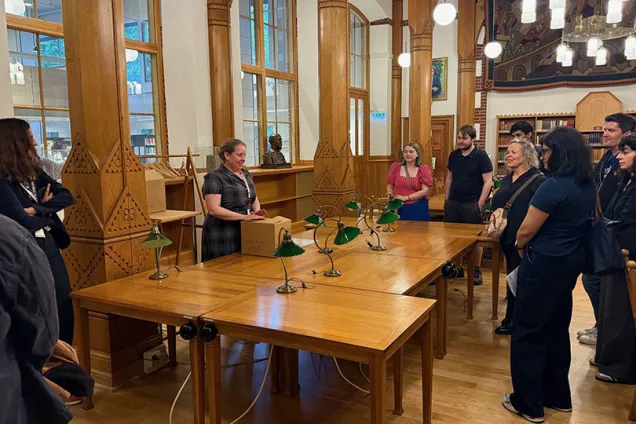 Bibliotekarie Maria Sjöberg öppnar en låda inför publik på Universitetsbiblioteket.