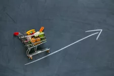 Bild på kundvagn med matvaror, ståendes på en ritad pil som pekar snett uppåt.