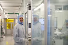 Photo of a woman in the clean room, wearing protective clothes.