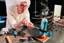 Pedagogen Stefan värmer en aluminiumburk över en gaslåga i showen Atomresan. Foto. 