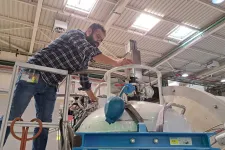 Bild på forskare som fyller på heliumtank.