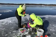 Bild på två forskare som står på en is och tar prover.