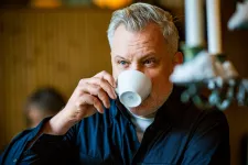 Joakim Zander dricker ur en kaffemugg. 
