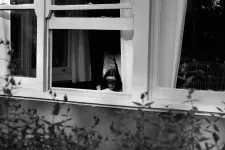 Lidande kvinna i fönster.