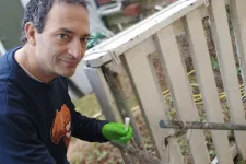 Man som sitter på huk vid en trappa.