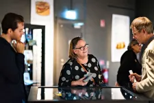 Besökare är samlade kring en glasmonter för att lyssna till en guide.